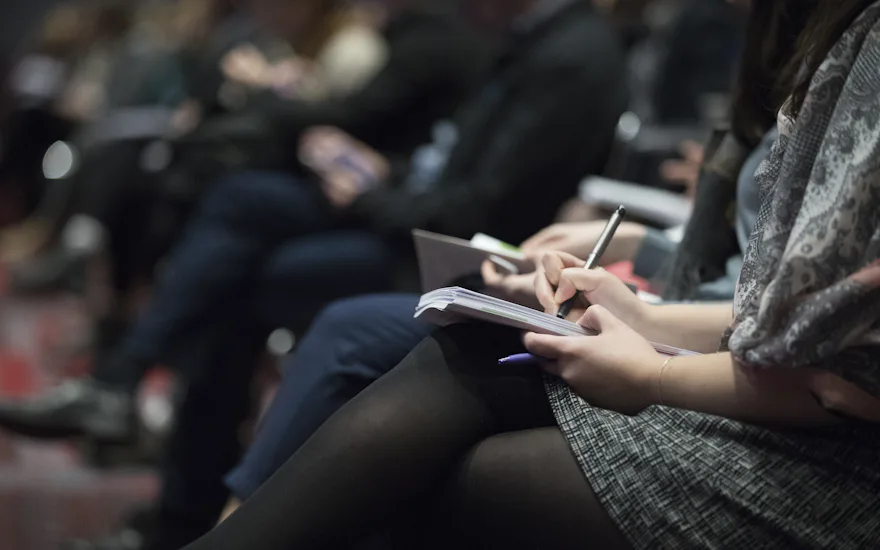 Asistentes tomando notas durante una charla